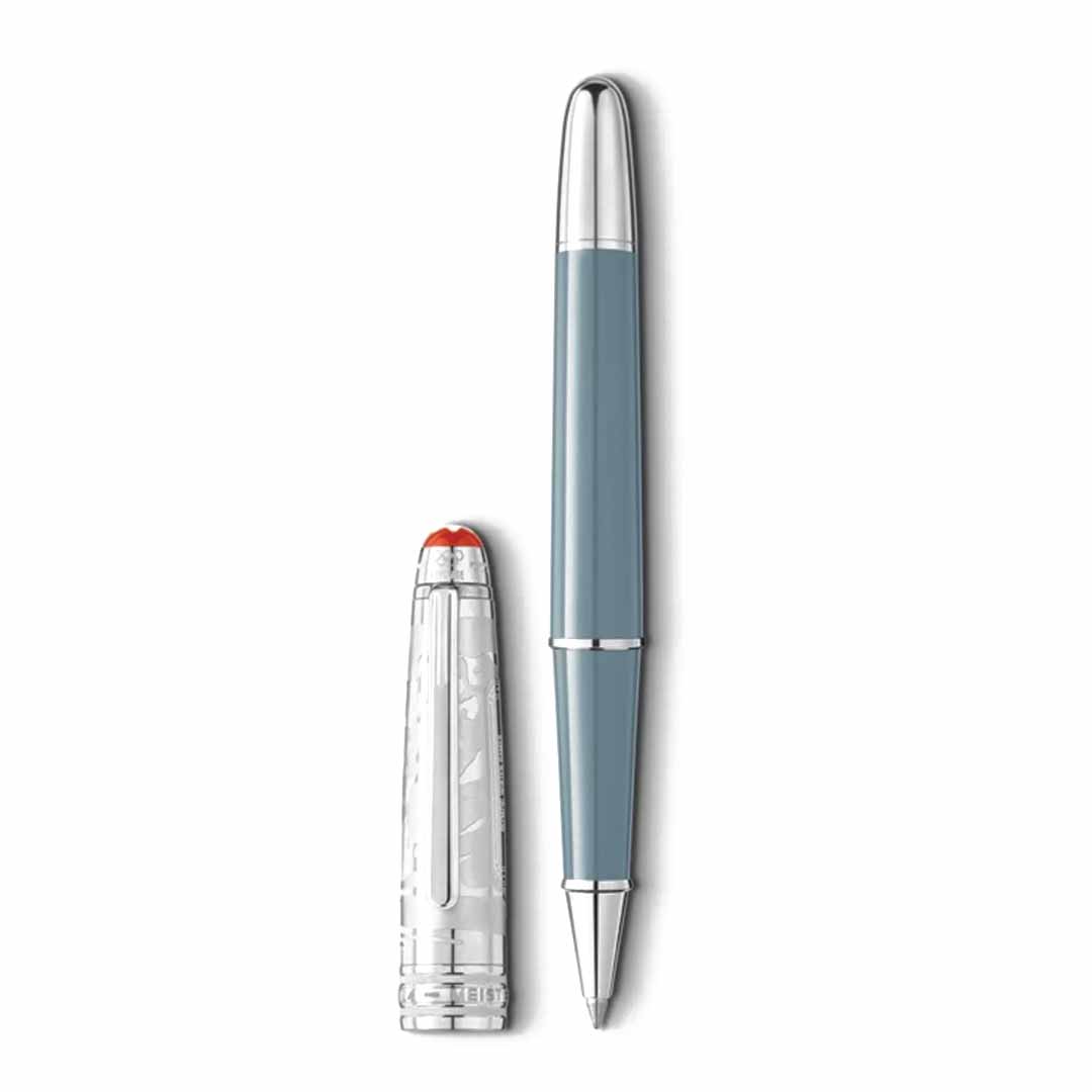 A stylish rollerball pen with a silver tip and a turquoise barrel rests beside its transparent cap, which features a red top. Reminiscent of the Montblanc Meisterstuck X Olympic Heritage Chamonix 1924 Doue Classique edition, the cap showcases intricate, artistic detailing befitting an Olympic champion.