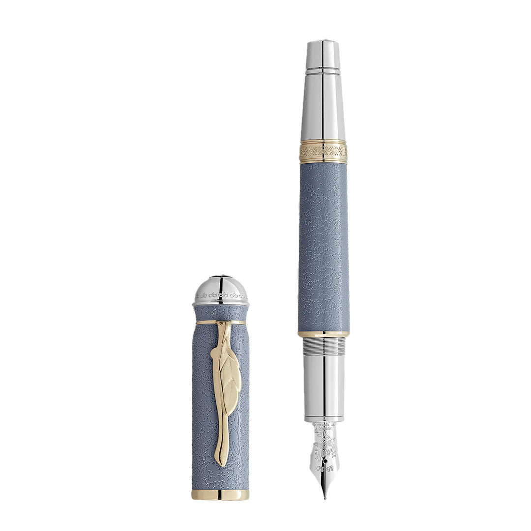The Montblanc Writers Edition Homage to Johann Wolfgang von Goethe Limited Edition Fountain Pen features a textured blue barrel, silver/gold accents, and a feather-shaped clip. The pen cap is shown separately beside the pen.
