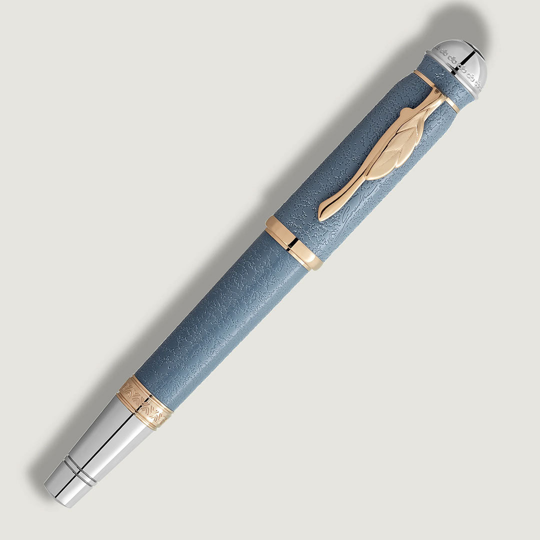 The Montblanc Writers Edition Homage to Johann Wolfgang von Goethe Limited Edition Fountain Pen features a textured light blue barrel, gold accents, silver cap, and gold feather-shaped clip on a light gray background, reflecting refined German literary elegance.