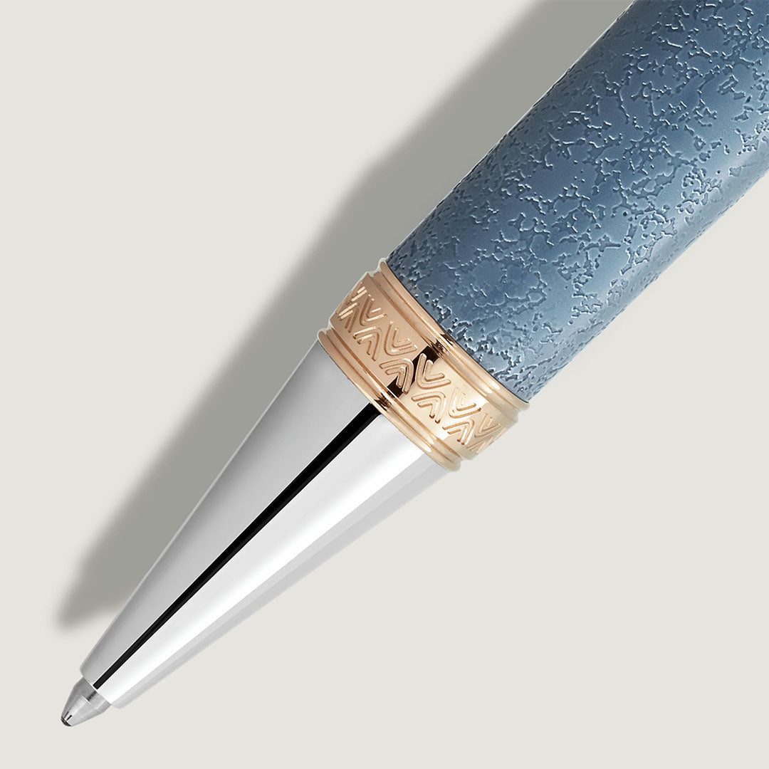 A close-up of the Montblanc Writers Edition Homage to Johann Wolfgang von Goethe Limited Edition Ballpoint Pen, featuring a textured blue body, silver tip, and patterned gold ring, evokes timeless style against a light background.