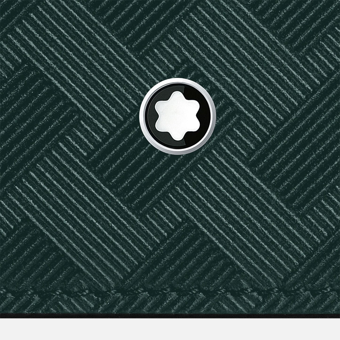 The Montblanc Extreme 3.0 Leather Card Holder 6cc showcases a close-up of its textured dark green surface with a woven pattern and a circular emblem featuring a white star in the center, echoing the elegance of British Green. This design accentuates the exquisite full-grain bovine leather, making it perfect for this sophisticated card holder by Montblanc.
