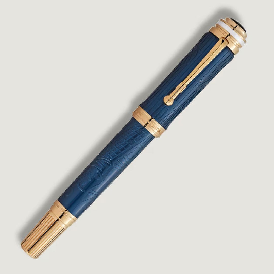 The Montblanc Great Characters Homage to Queen Special Edition Fountain Pen features a blue barrel with intricate patterns, gold accents, and a gold clip, and is displayed diagonally on a light background.