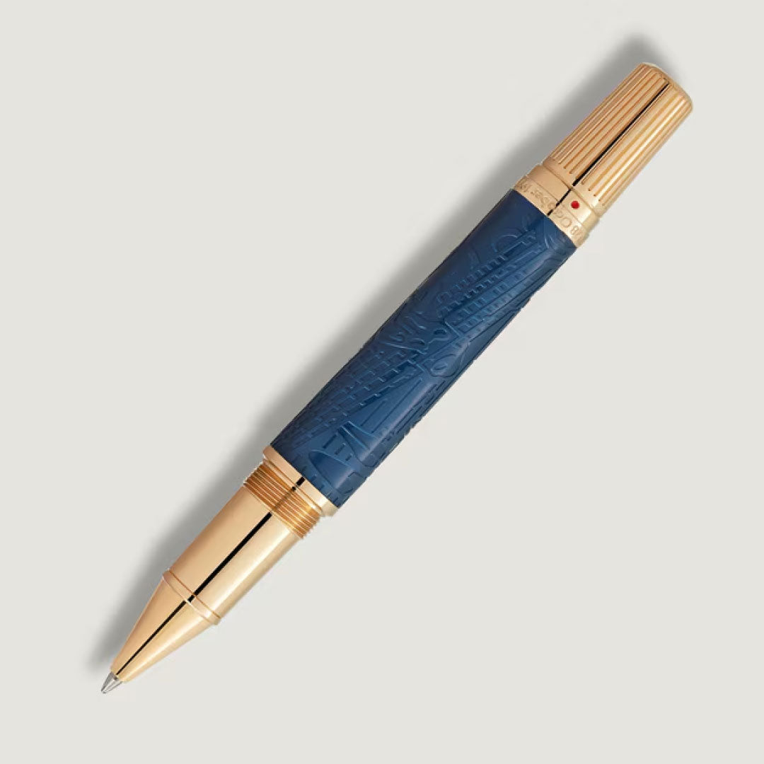 The Montblanc Great Characters Homage to Queen Special Edition Rollerball Pen features a blue textured barrel with gold-colored accents on the tip, cap, and bands, shown against a plain light gray background.