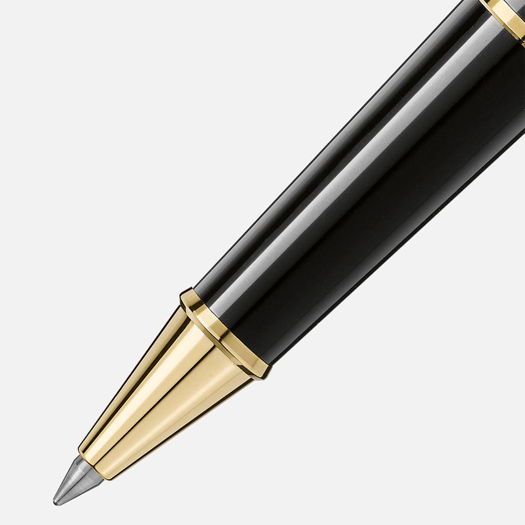 Close-up of the tip of a Montblanc Meisterstuck Yellow Gold Coated Rollerball Pen, featuring a sleek black finish and gold accents, isolated on a white background.