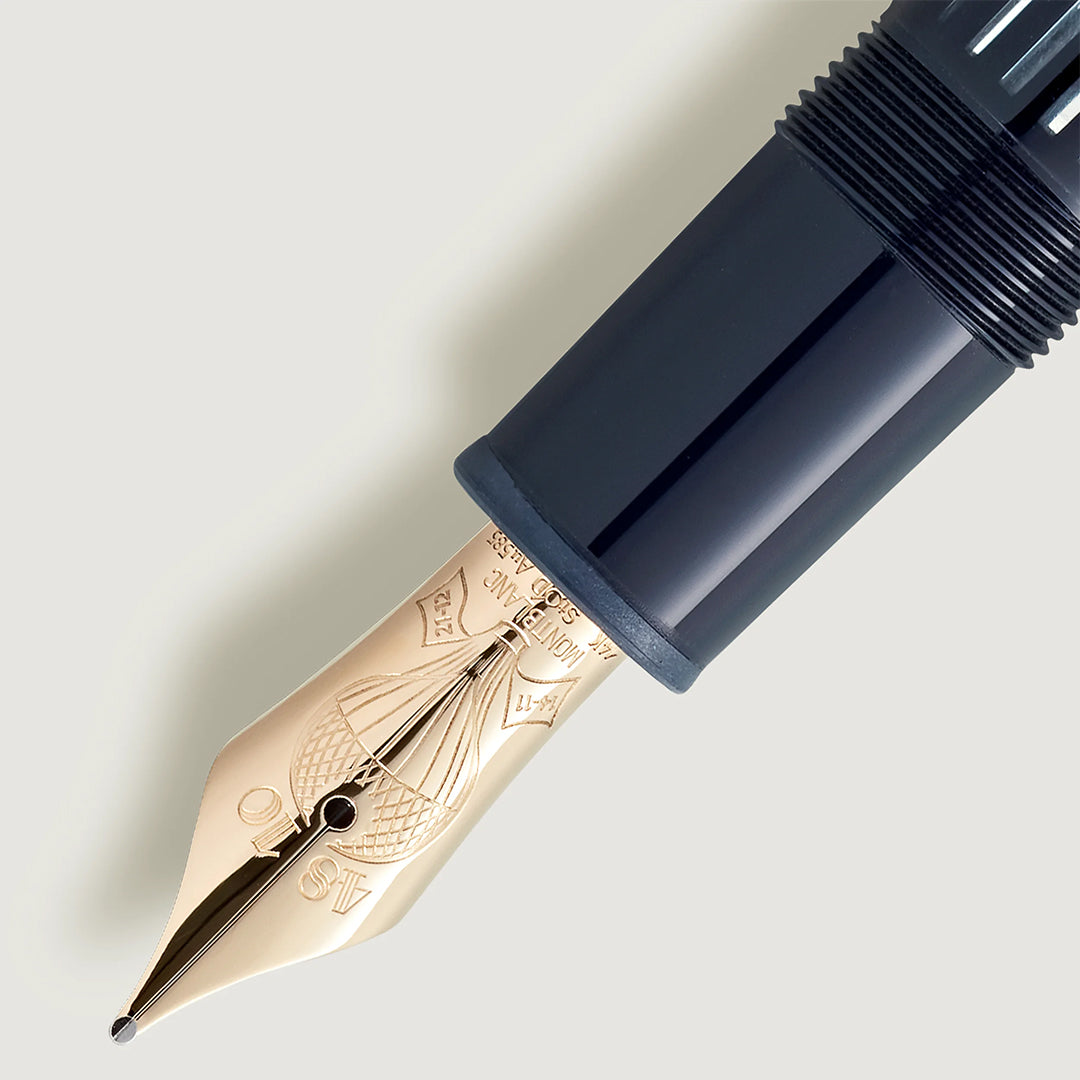 Close-up of a gold nib with intricate engravings on the Montblanc Meisterstuck Around the World in 80 Days Legrand Fountain Pen, reflecting light elegantly against a black barrel and plain background, evoking the classic adventure theme.
