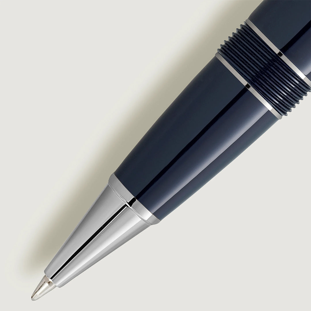 Close-up of a sleek black and silver tip on a light gray background, complemented by dark blue resin. The modern design features smooth metallic accents reminiscent of the Montblanc Meisterstuck Around the World in 80 Days Legrand Rollerball Pen quality.