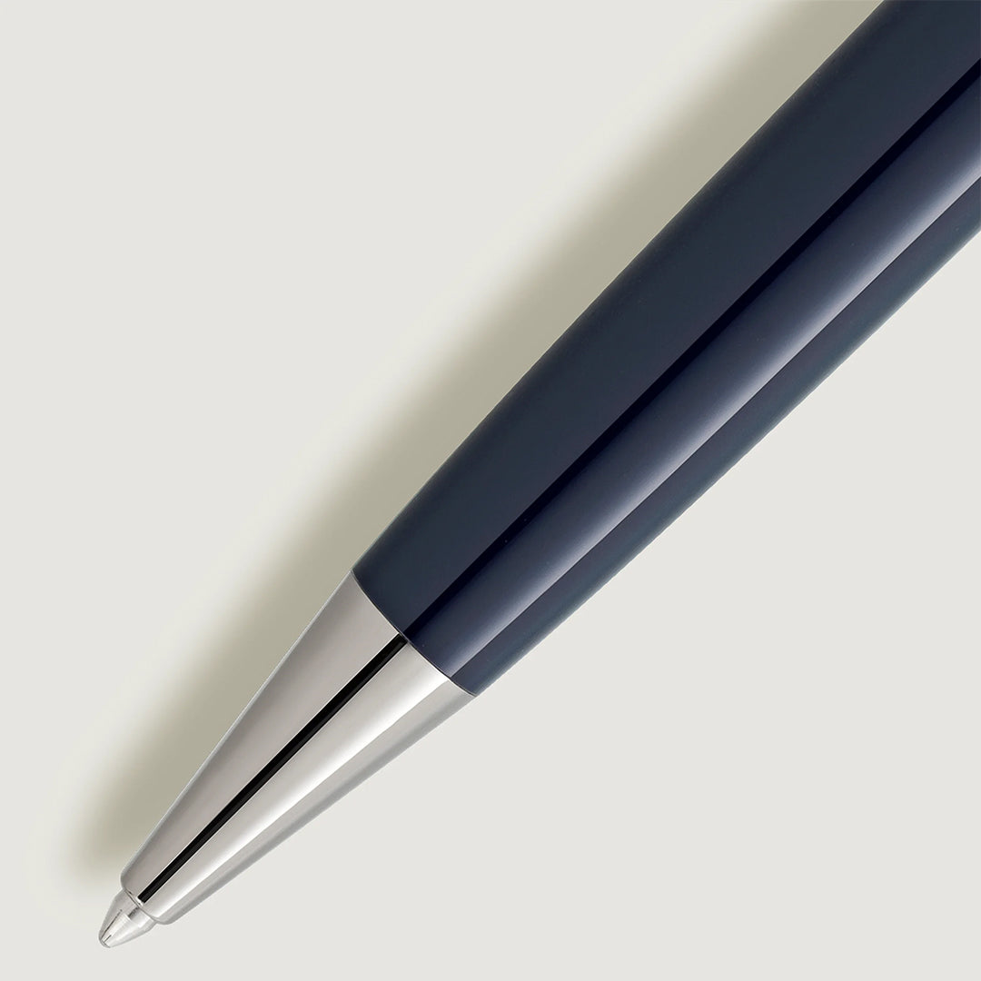 Close-up of a Montblanc Meisterstück Around the World in 80 Days Midsize Ballpoint Pen, featuring a dark blue barrel with a shiny silver tip, against a light gray background.