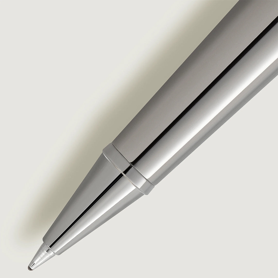 Close-up of the sleek, metallic tip of a Montblanc Meisterstuck Around the World in 80 Days Doue Classique Rollerball Pen on a light gray background. Its shiny, smooth surface and modern design cast a soft shadow to the left.