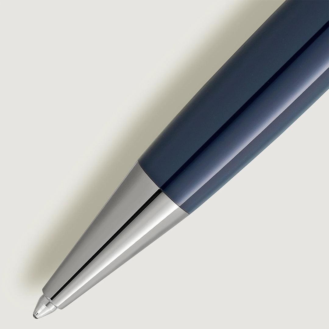 Close-up of a sleek Montblanc Meisterstück Around the World in 80 Days - Doue Classique Ballpoint Pen in dark blue and silver against a light gray background, highlighting its smooth, reflective finish and modern design inspired by Jules Verne's adventures.