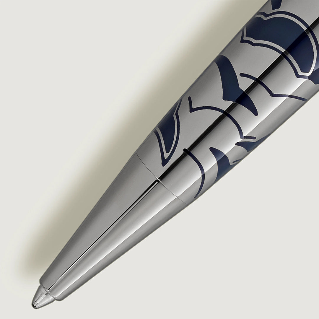 A close-up of the Montblanc Meisterstück Around the World in 80 Days Solitaire Midsize Ballpoint Pen, featuring dark blue abstract patterns on its precious metal body, set against a light gray background.