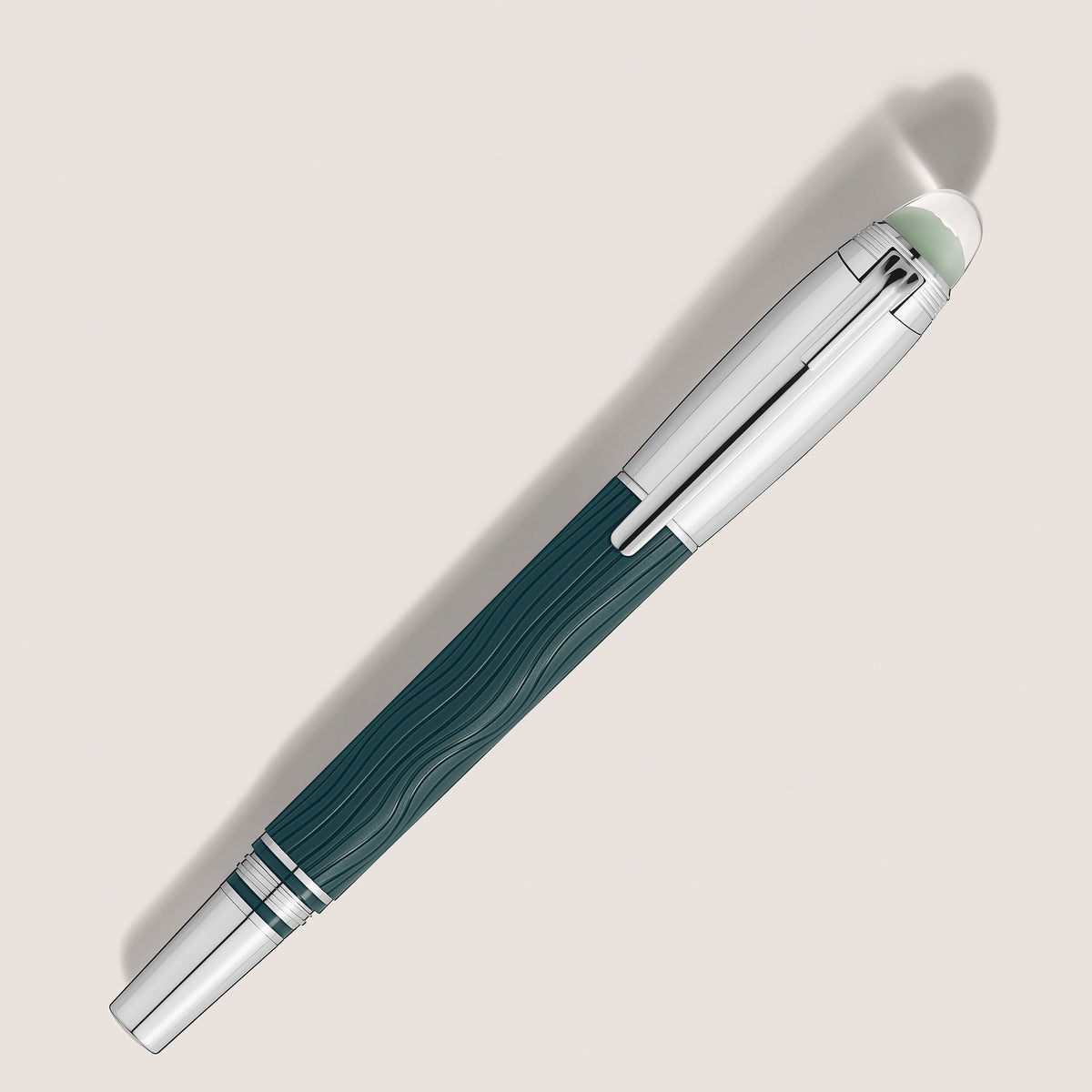 The Montblanc StarWalker PolarGreen Doue Fineliner Pen features a wavy teal barrel, silver cap and accents, and a white finial, evoking the Northern Lights against a light backdrop with soft shadow.