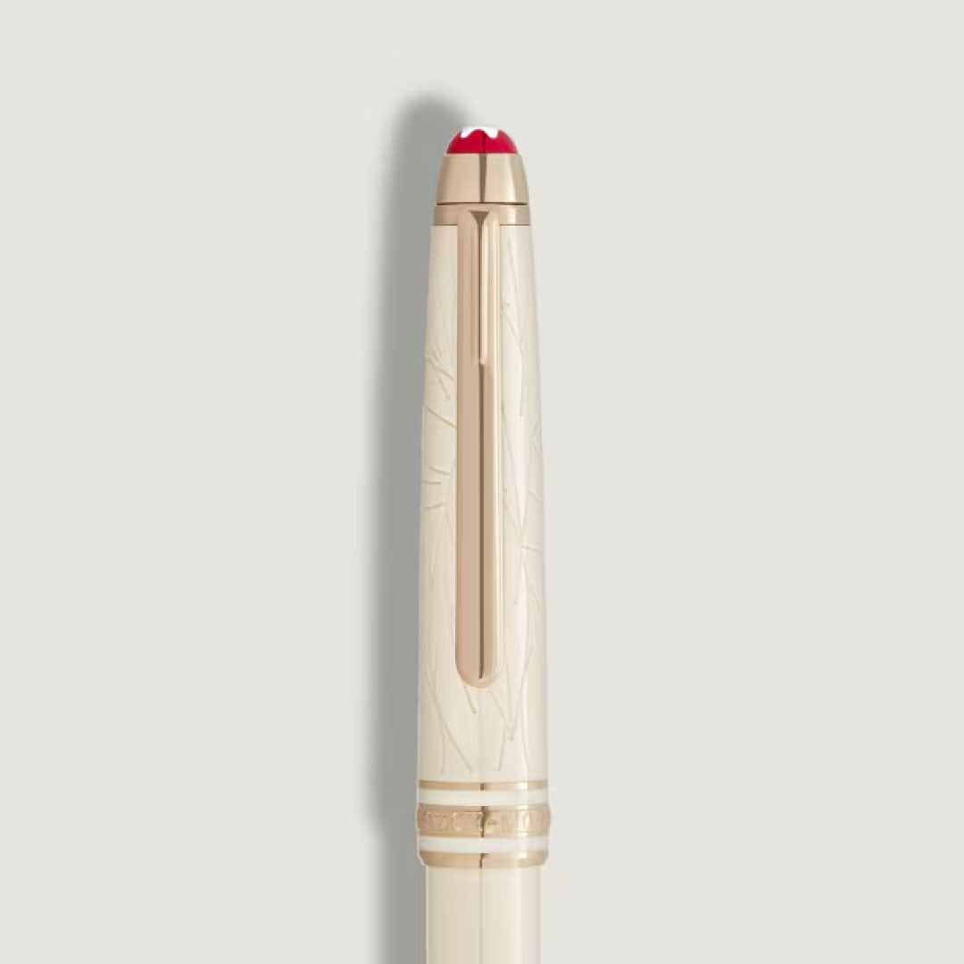 A close-up of the Montblanc Meisterstuck Romeo & Juliet Classique Ballpoint Pen, crafted from ivory-colored precious resin with a gold clip, red-tipped cap, and subtle engravings on the cap, set against a light gray background.