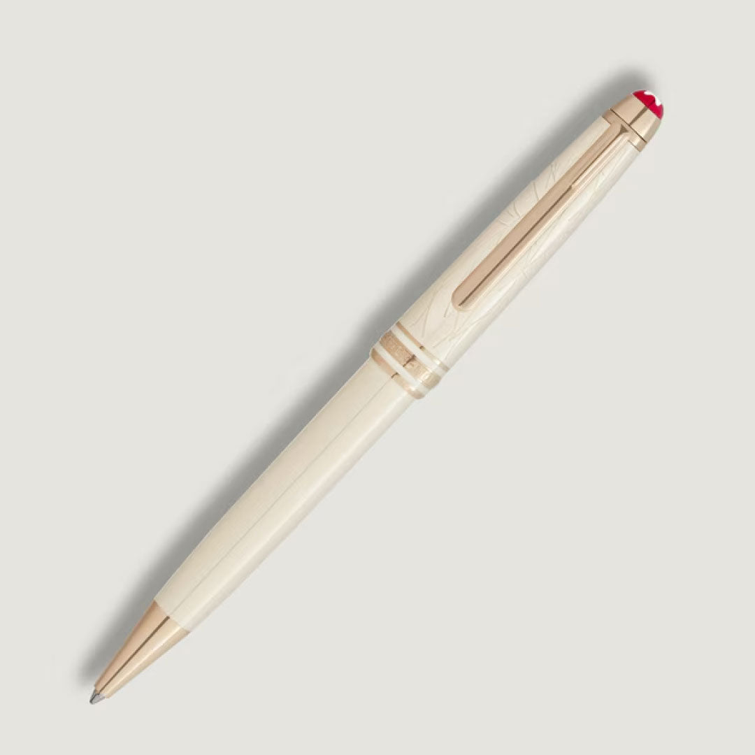 A Montblanc Meisterstuck Romeo & Juliet Classique Ballpoint Pen by Montblanc, featuring ivory-colored resin, gold accents, and a red-tipped cap, is placed diagonally on a light gray background.