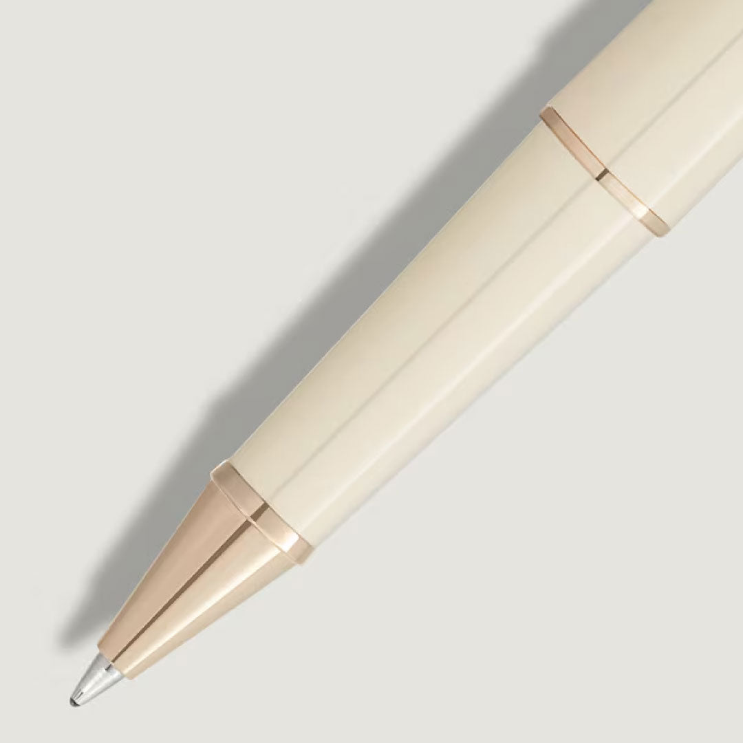 A close-up of the cream Montblanc Meisterstuck Romeo & Juliet Doue Classique Rollerball Pen, featuring gold accents, positioned diagonally on a light gray background with a soft shadow.