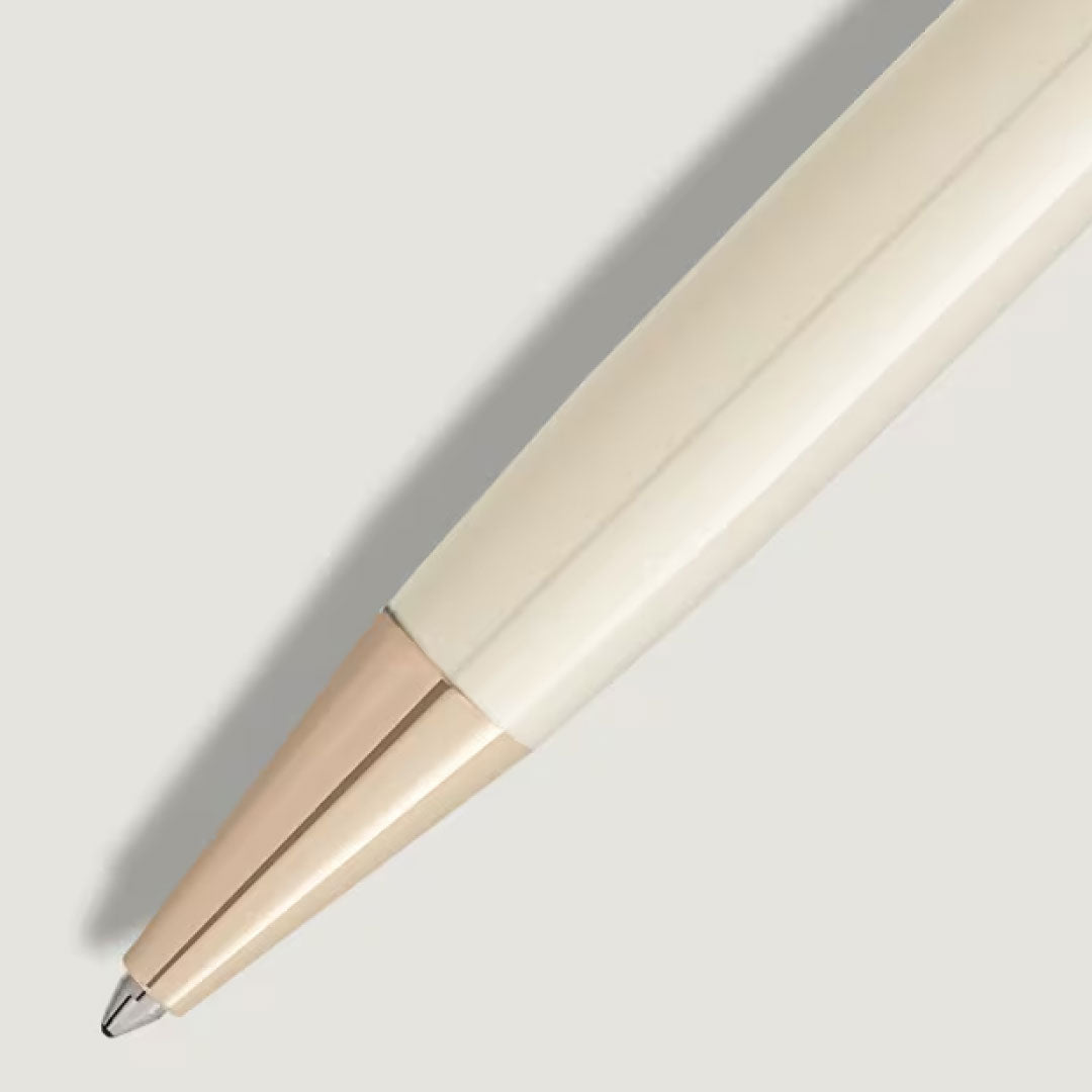 A close-up of the Montblanc Meisterstuck Romeo & Juliet Doue Classique Ballpoint Pen, showcasing its glossy metallic tip and smooth cream barrel, positioned diagonally on a light gray background.