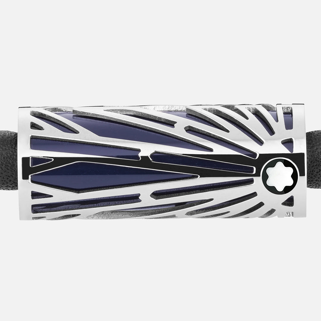 A close-up of the Montblanc Meisterstuck The Origin Collection Leather Bracelet showcases an intricate solitaire pattern in silver and black, resembling rays from a star emblem, beautifully complementing its stainless steel finish against the textured black surface.