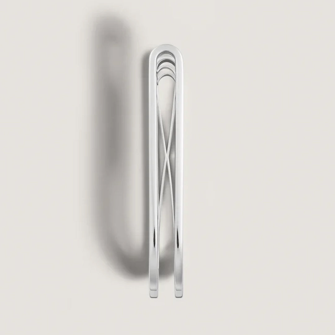 A Montblanc Great Characters Homage To The Great Gatsby Stainless Steel Money Clip stands upright on a light gray backdrop, casting a soft left shadow. Its minimalist design echoes the opulent elegance reminiscent of *The Great Gatsby*.