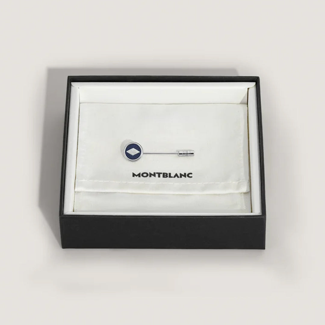 The Montblanc Great Characters Homage to The Great Gatsby Stainless Steel Lapel Pin features a sleek silver design with a circular blue emblem, exuding elegance in a black box with a soft white interior and the iconic Montblanc logo, epitomizing timeless sophistication.