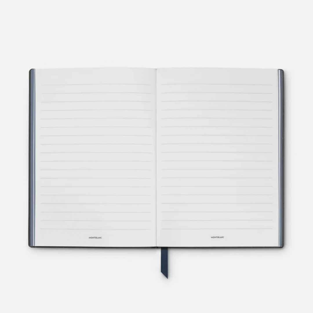 The Montblanc #146 Writers Edition Homage to Jane Austen Notebook is an open leather notebook featuring lined pages and a black ribbon bookmark at the center. This elegant notebook has a dark border and rests against a light gray backdrop, evoking a style reminiscent of something Jane Austen might have used.