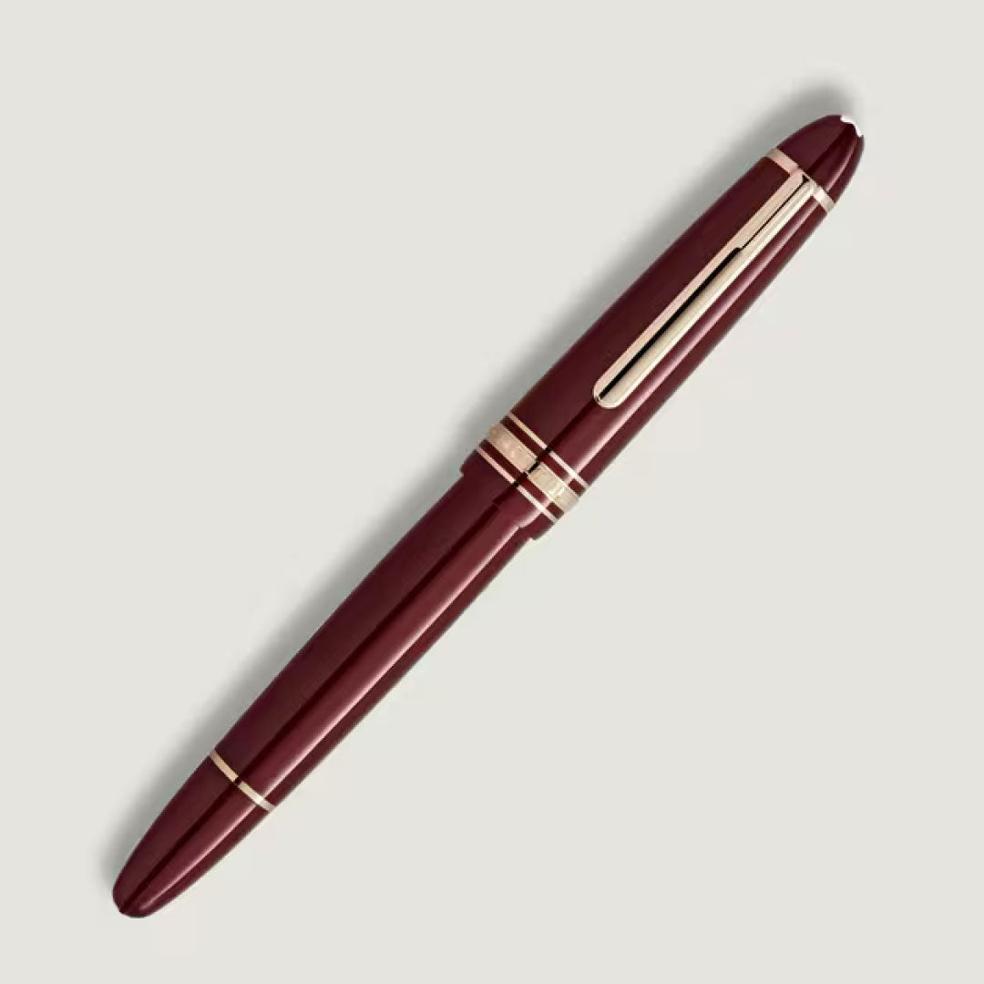 A Montblanc Meisterstuck Burgundy Red Legrand Rollerball Pen is displayed diagonally on a plain light gray background.