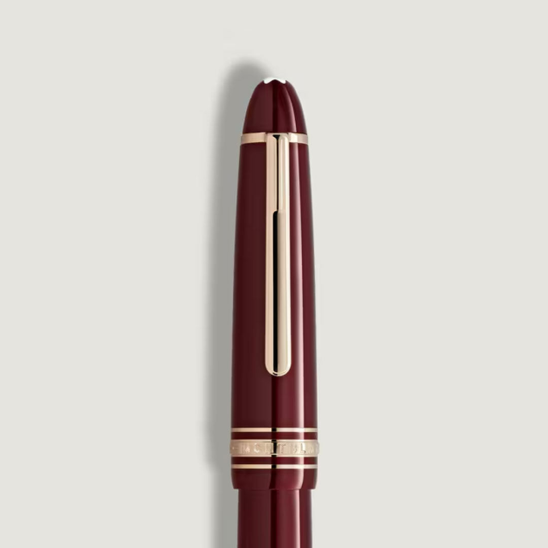 A Montblanc Meisterstuck Burgundy Red Legrand Rollerball Pen by Montblanc is shown vertically against a plain light gray background.