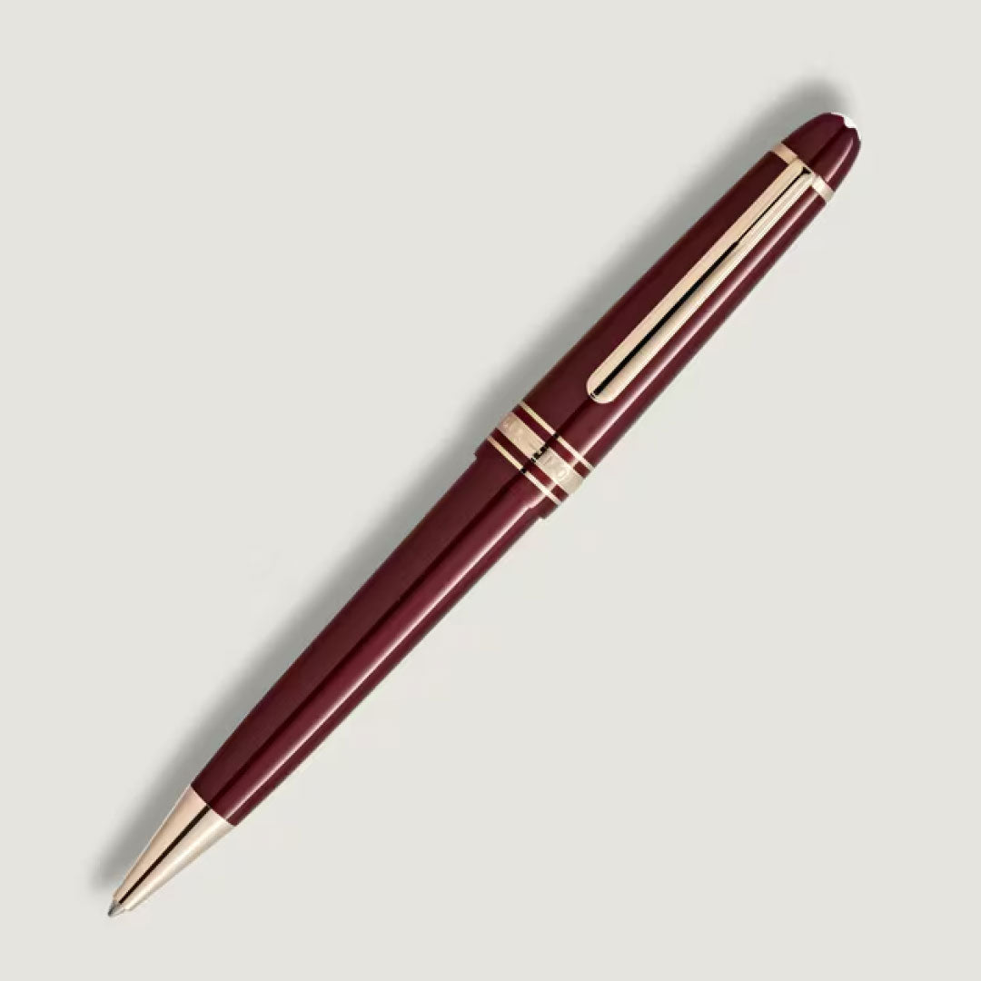 The Montblanc Meisterstuck Burgundy Midsize Ballpoint Pen, featuring gold fittings and a gold clip, is shown diagonally on a light gray background.