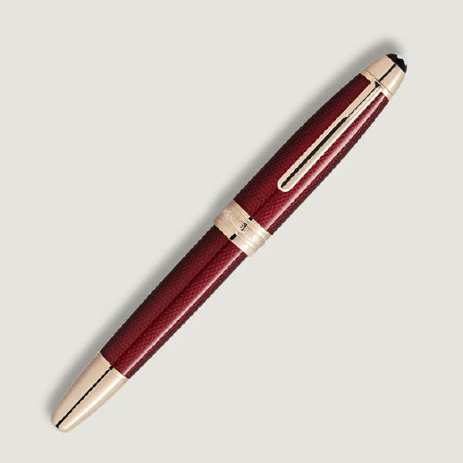 A Montblanc Meisterstück Solitaire Golden Hour Rollerball Pen, featuring gold-coated fittings and a textured body, displayed diagonally on a light gray background.