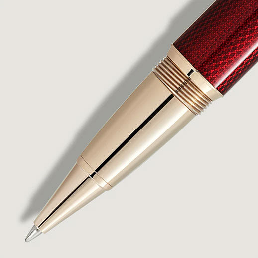 Close-up of a Montblanc Meisterstück Solitaire Golden Hour Rollerball Pen, featuring gold-coated fittings and a burgundy lacquer barrel, casting a soft shadow on a light background.