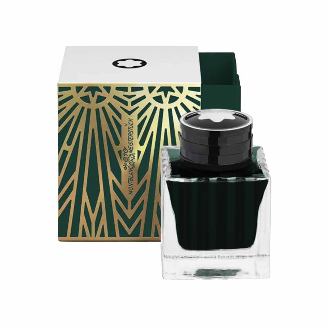 A square glass ink bottle of Montblanc Meisterstück The Origin Collection Green - 50ML is displayed in front of an open box. The box is adorned with an Art Deco design, featuring gold geometric patterns on a green background. Both the bottle cap and the top of the box showcase a white star logo, perfectly complementing Meisterstück writing instruments.