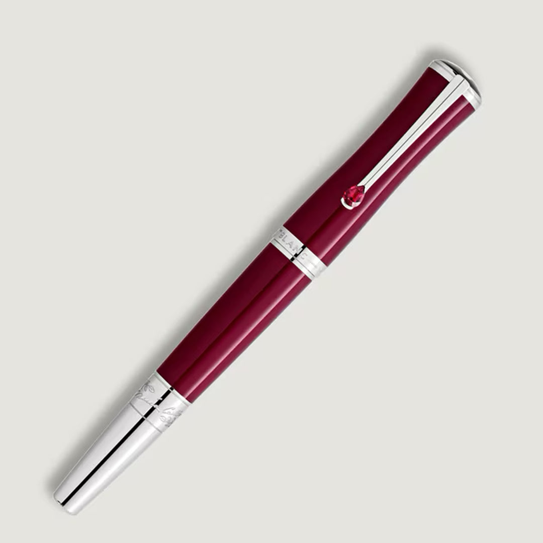 A Montblanc Maria Callas Special Edition Rollerball Pen featuring silver accents and a red gem on the clip is displayed against a light gray background.