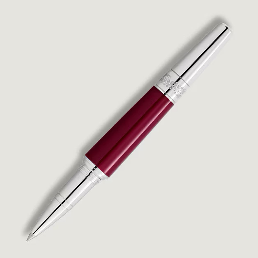 The Montblanc Maria Callas Special Edition Rollerball Pen features maroon and silver tones with a metallic cap, showcased diagonally on a light gray background, evoking the grace of an operatic diva.