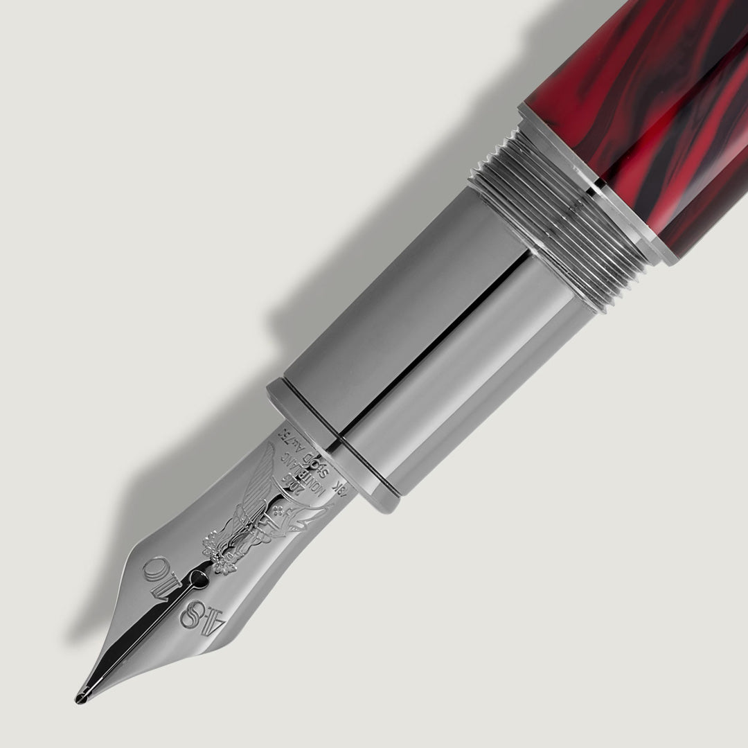 A close-up of the Montblanc Writers Edition Homage to Bram Stoker Limited Edition Fountain Pen, featuring a shiny silver nib and red marbled barrel, against a plain light background.