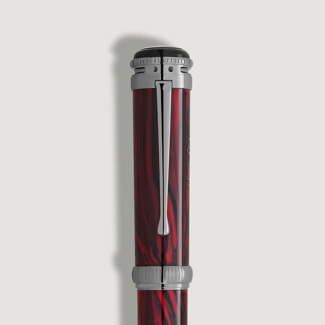 A close-up of the top half of the Montblanc Writers Edition Homage to Bram Stoker Limited Edition Rollerball Pen, featuring red marbling, silver accents, and a shiny silver clip, set against a plain light background.