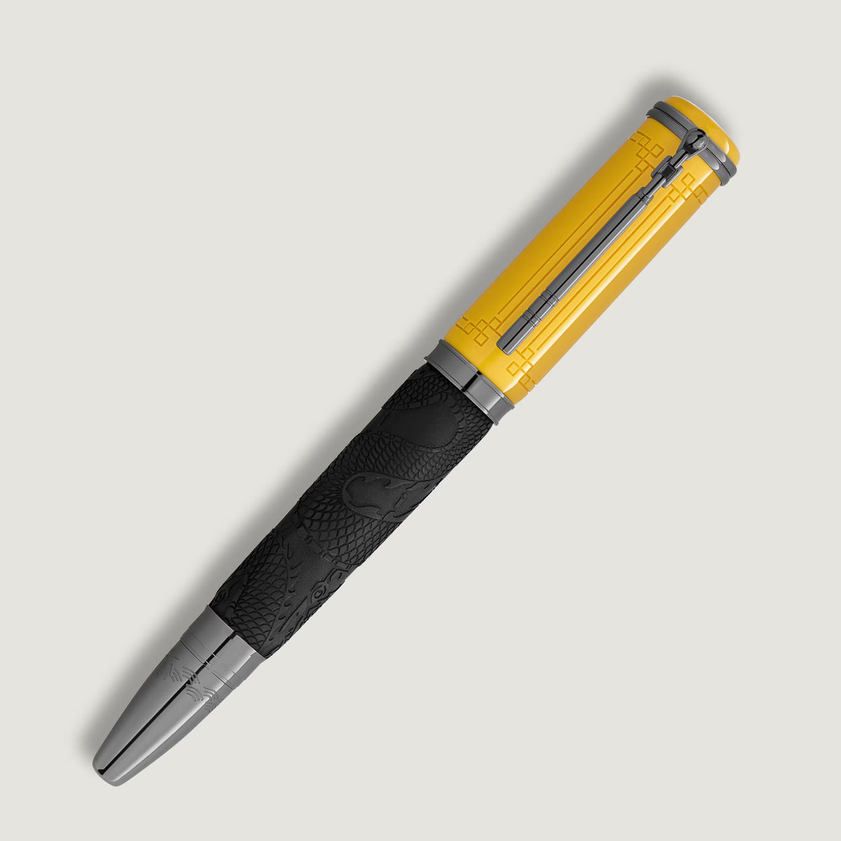 Montblanc Great Characters Bruce Lee Special Edition Rollerball Pen with a yellow cap featuring a geometric pattern, a black barrel embossed with dragon imagery, and dark metallic trim.