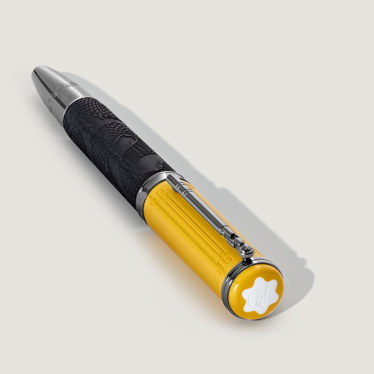 A Montblanc Great Characters Bruce Lee Special Edition Rollerball Pen featuring a yellow cap and a black barrel with a dragon motif, accented with silver-tone metal details and a white emblem on the end of the cap.