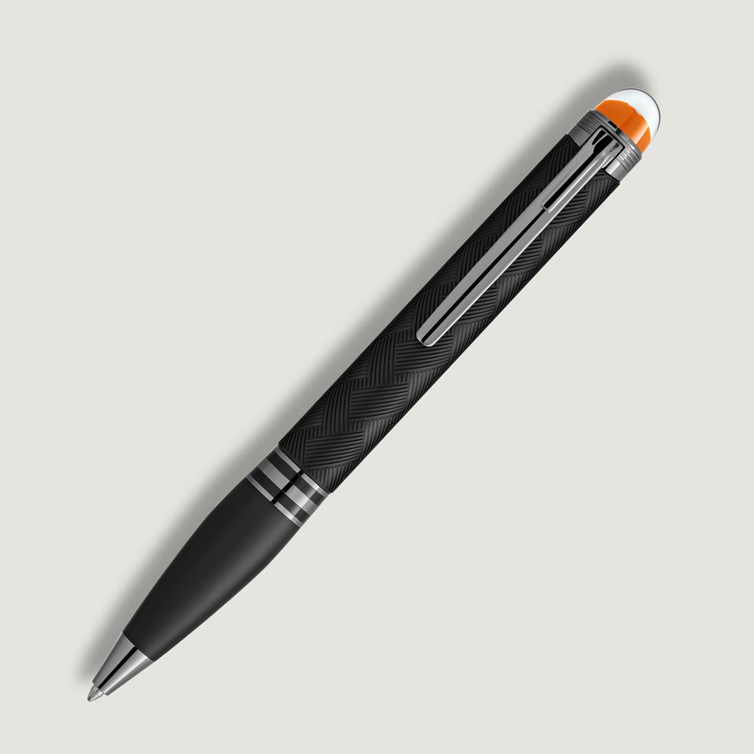 The Montblanc StarWalker Extreme Precious Resin Ballpoint Pen features a sleek black barrel, silver accents, an orange-tipped cap, and ruthenium-coated fittings, standing out for its modern design on a light background.