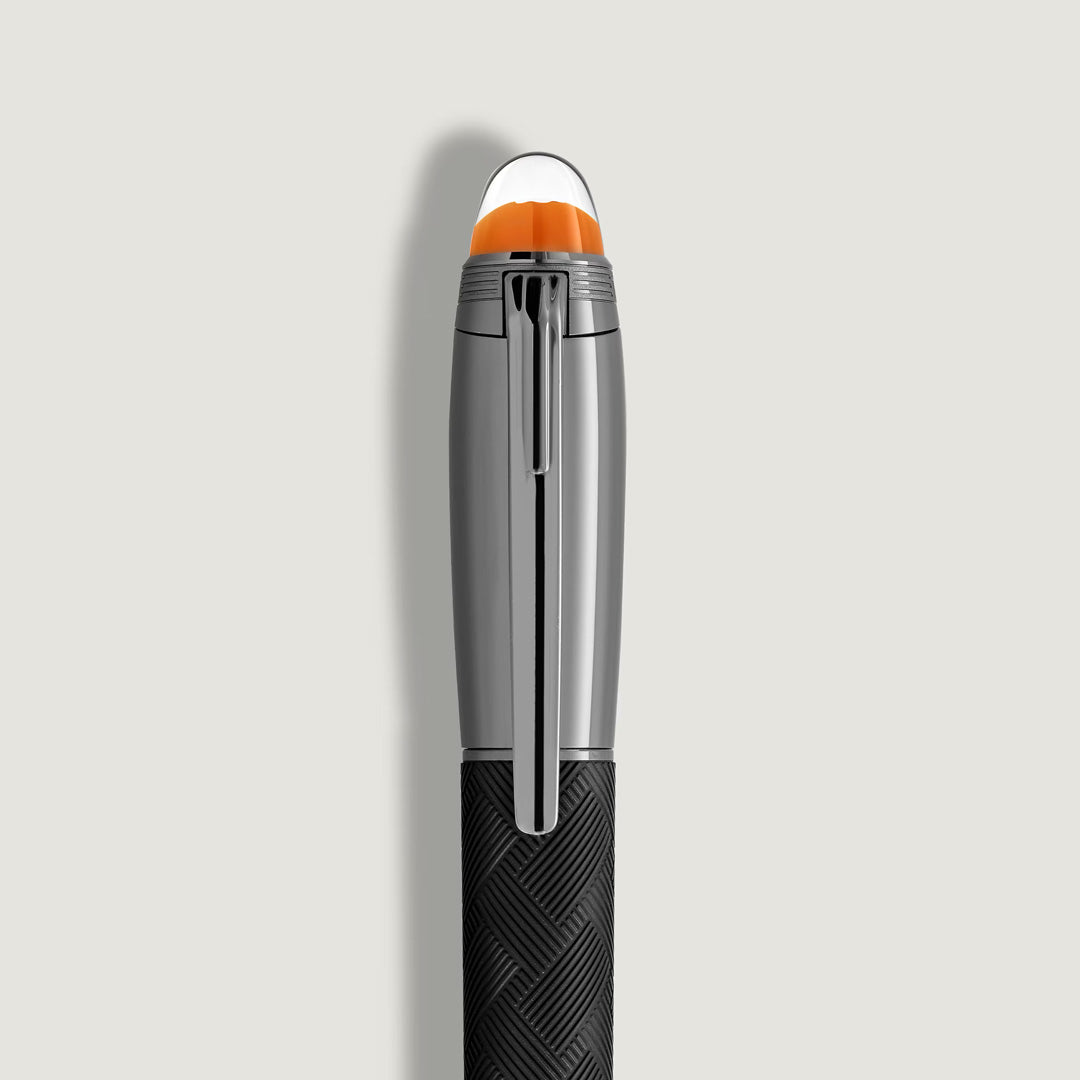 A close-up of the Montblanc StarWalker Extreme Doue Fountain Pen highlights its black textured body, shiny ruthenium-coated clip, and orange-topped cap, exemplifying Montblanc’s refined design against a light gray background.