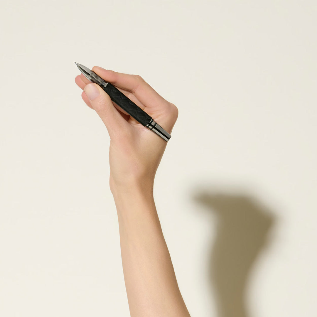 A hand holds the Montblanc StarWalker Extreme Doue Fineliner Pen against an off-white background, its shadow cast on the wall—a striking display of Montblanc’s refined writing instrument.