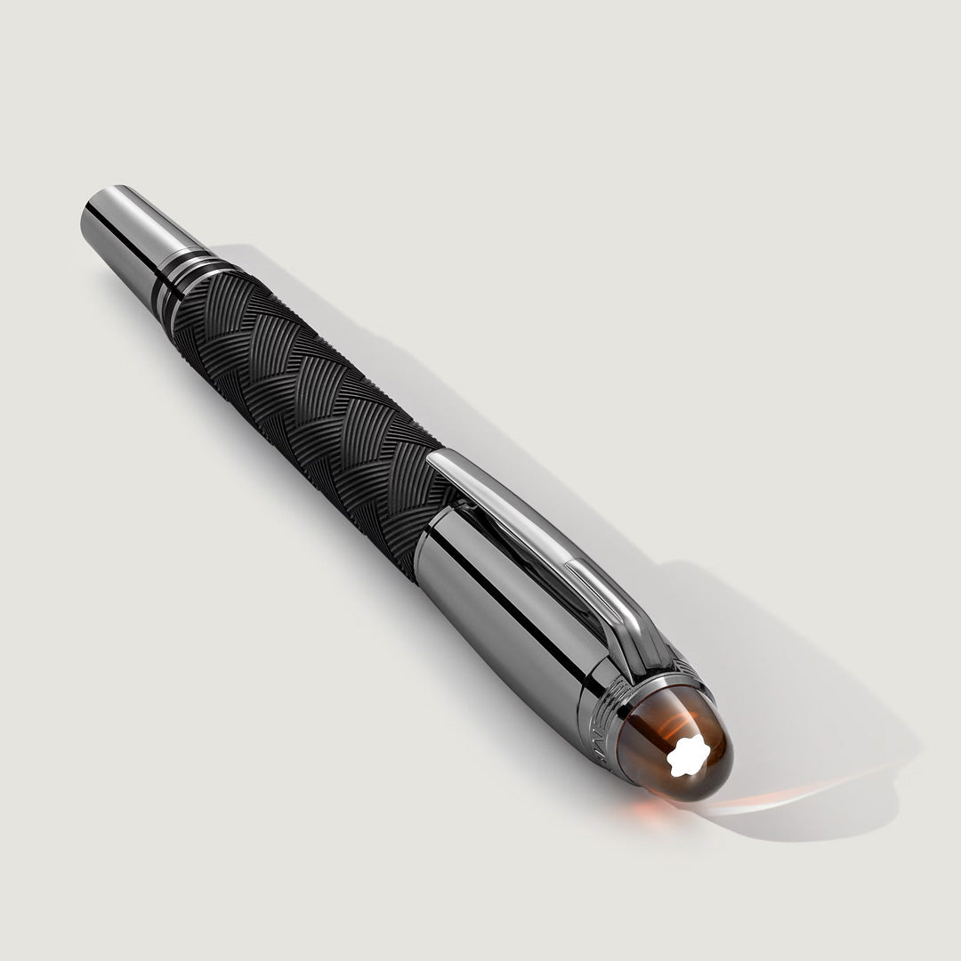 The Montblanc StarWalker Extreme Doue Fineliner Pen, a luxury black and silver pen with a textured grip, shiny cap, and white star emblem, rests on a light gray surface—a refined writing instrument by Montblanc.