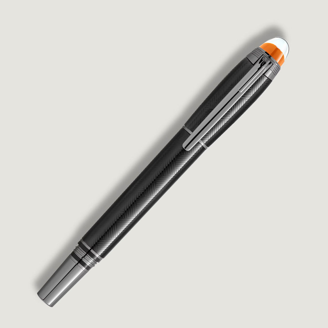 The Montblanc StarWalker Extreme Metal Fineliner Pen, in sleek black with silver accents and an orange-white cap tip, stands out as a modern writing instrument, elegantly displayed against a light gray background.