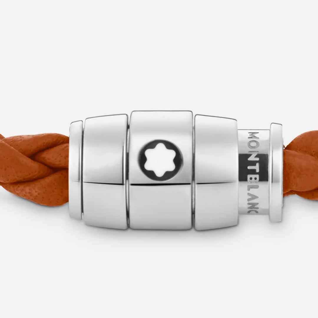 An orange braided leather bracelet from the Montblanc Meisterstück Collection is accompanied by a polished stainless steel clasp adorned with three cylindrical segments and the iconic star emblem at its center, reflecting a harmonious blend of elegance and sophistication.