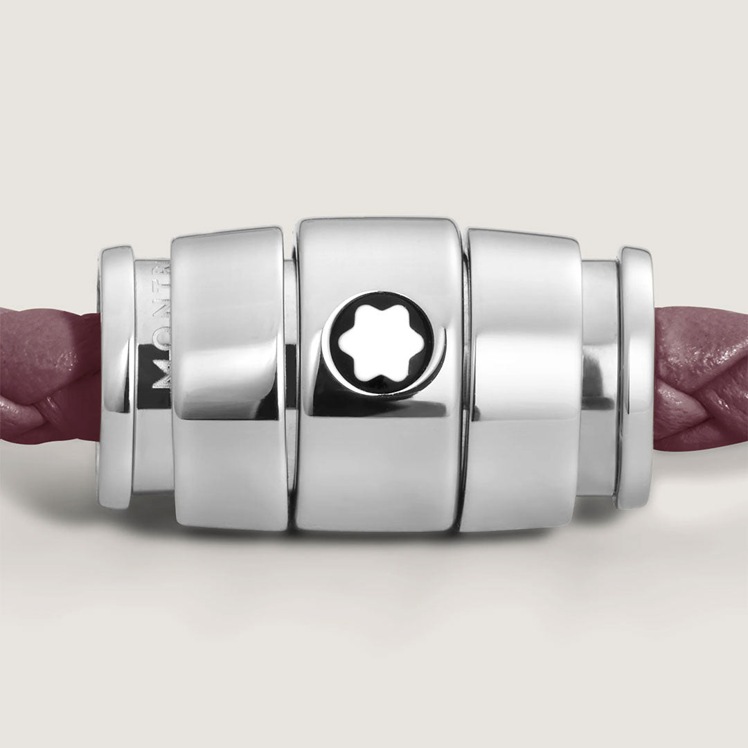 Close-up of the Montblanc Meisterstück 3 Rings Cassis Leather Bracelet, featuring a silver cylindrical clasp with a star-shaped cutout and a braided mauve calf-skin leather strap on a light background.