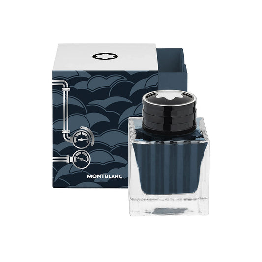 A square 50ml Montblanc Meisterstuck Around the World in 80 Days Coal Blue Ink bottle sits before a decorative blue wave-patterned box with white accents, marking it as a special edition.