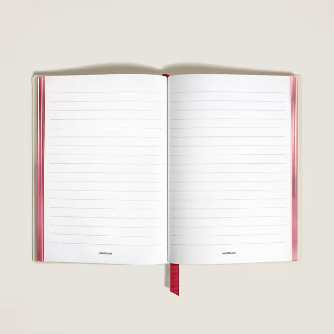 The Montblanc Meisterstück Romeo & Juliet Medium Notebook lies open on a light surface, displaying its lined white pages, bold red spine, and red ribbon bookmark—classic luxury from Montblanc.