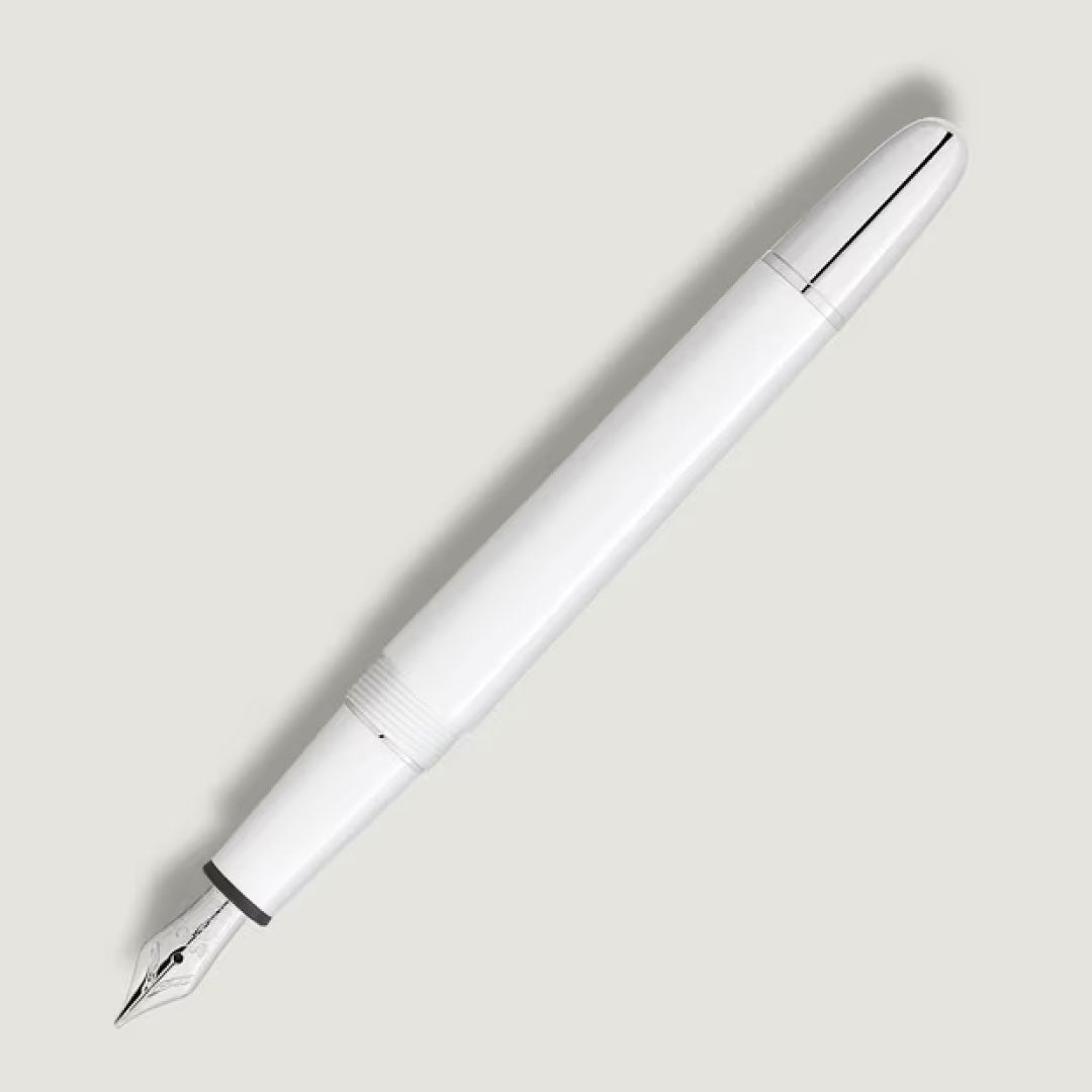 A Montblanc Meisterstuck White Classique Fountain Pen M with silver accents rests diagonally on a light grey background, the cap to the right and the nib pointing bottom left.