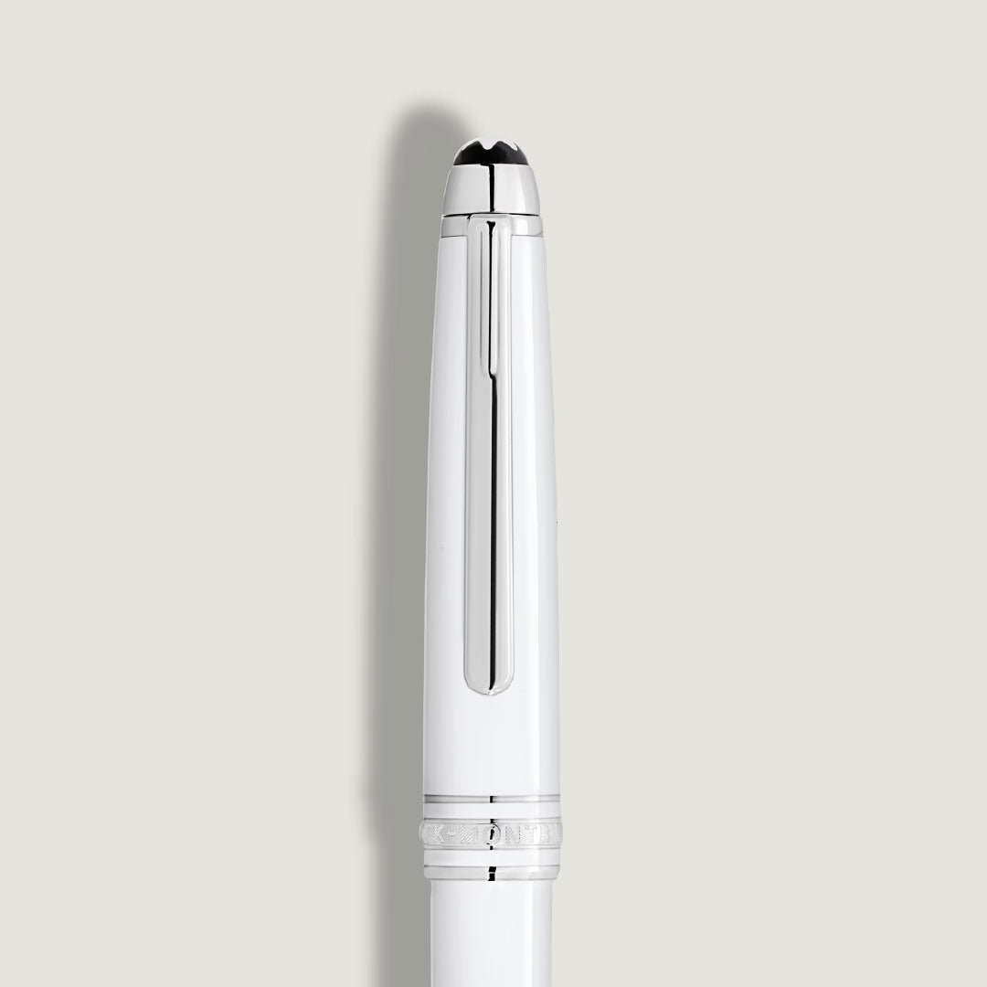 A close-up of the Montblanc Meisterstuck White Classique Ballpoint Pen shows its platinum-coated fittings and silver clip, set against a light gray background.
