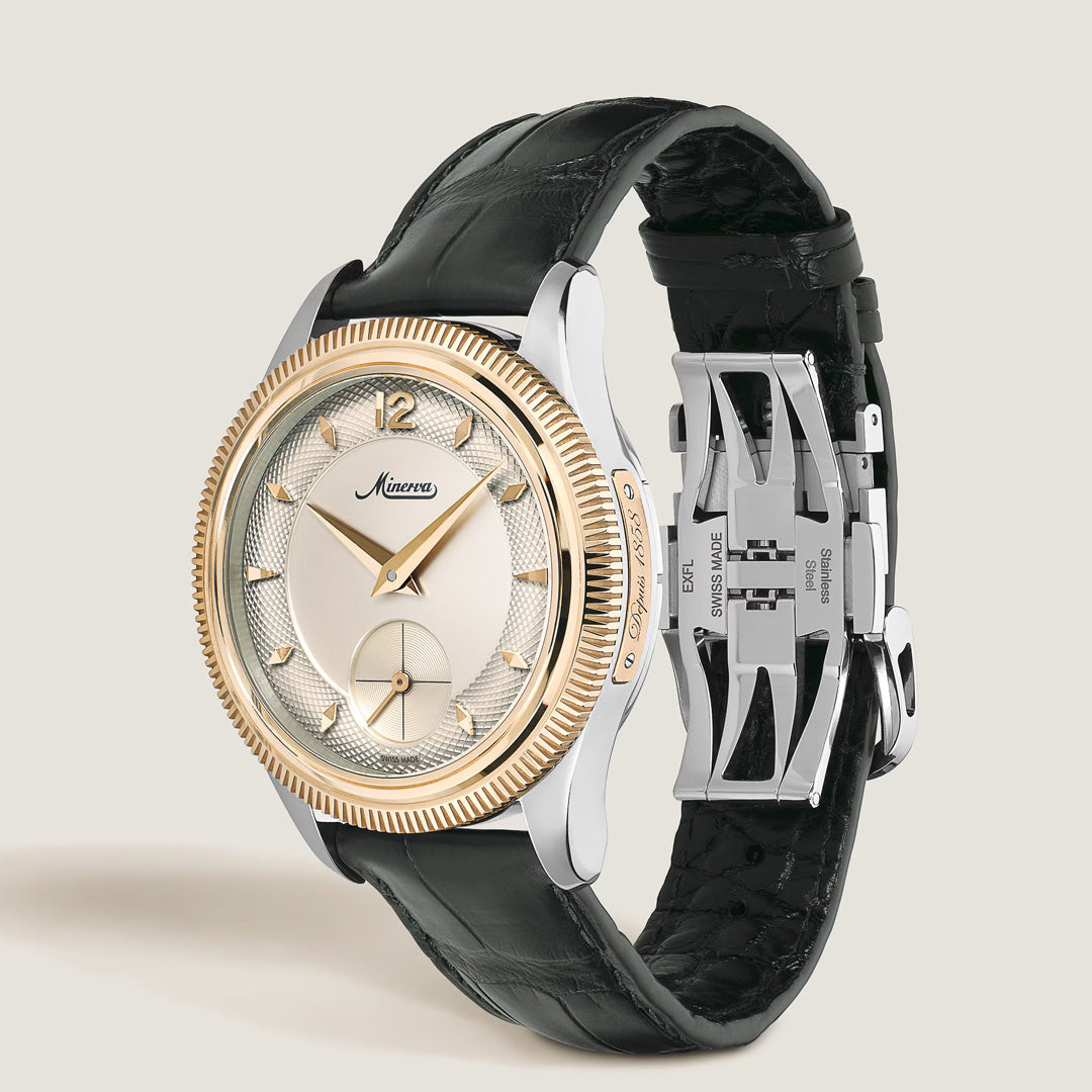 The Montblanc Minerva The Unveiled Crownless Manual Winding 41.5mm Watch features a textured rose gold bezel, a sophisticated silver and gold dial, a refined black leather strap, and a sleek silver deployment clasp. Displayed at an angle on a light background, the Montblanc brand name is clearly visible on the elegant watch face of this striking timepiece.
