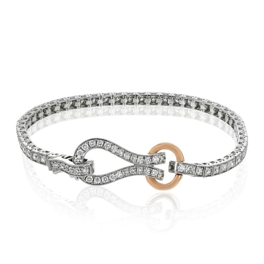 Introducing the Simon G. 18K White and Rose Gold Diamond Buckle Bracelet, a stunning piece featuring round diamonds in a diamond-studded design with an infinity-shaped clasp. Accentuated by a small gold circle, this bracelet offers an elegant and intricate pattern along its entire length, providing a timeless sophistication characteristic of the Simon G brand.