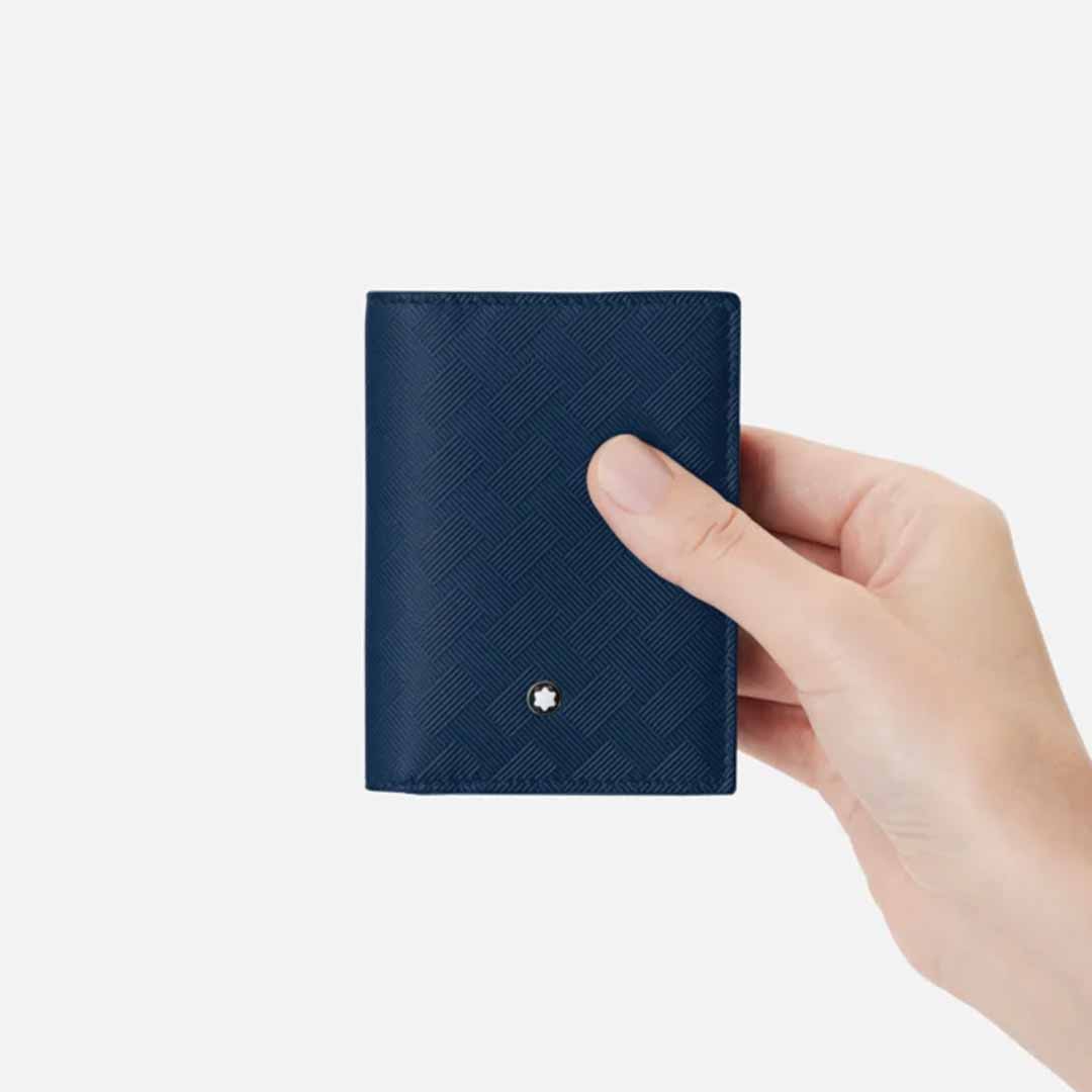 A hand holds the Montblanc Extreme 3.0 4cc Leather Blue Card Holder, a compact accessory crafted from dark blue full-grain leather and adorned with a silver Montblanc emblem on the lower front. This elegant card holder, set against a plain white background, offers convenient credit card slots for organized storage.