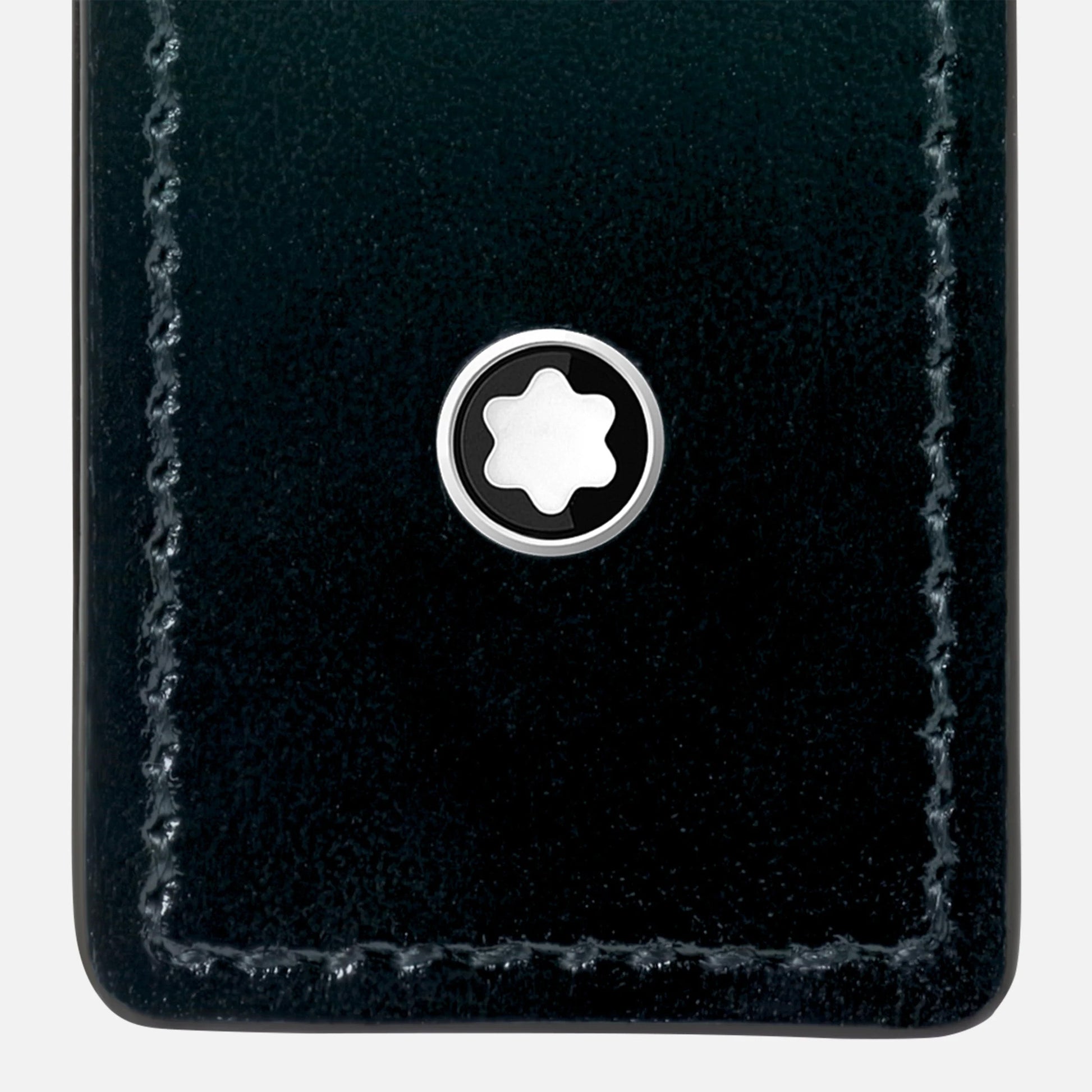 A close-up of the Montblanc Meisterstuck Single Pen Pouch shows detailed edge stitching and a circular metal emblem with a six-pointed white star on black. The black leather pouch is perfect for stylishly housing your Meisterstück pen.